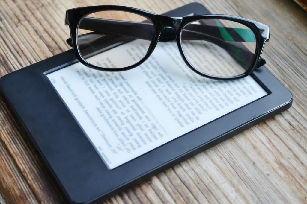 Black-framed glasses on top of a Kindle